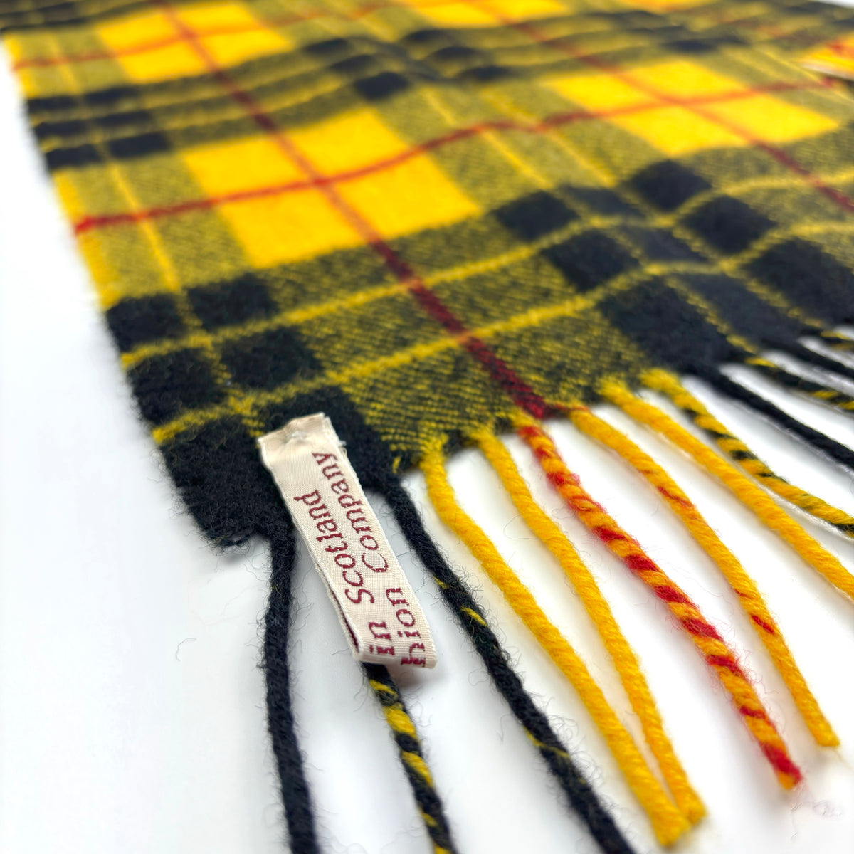 MacLeod Dress Modern Tartan Scarf, angled close-up of fringe, label on fabric edge